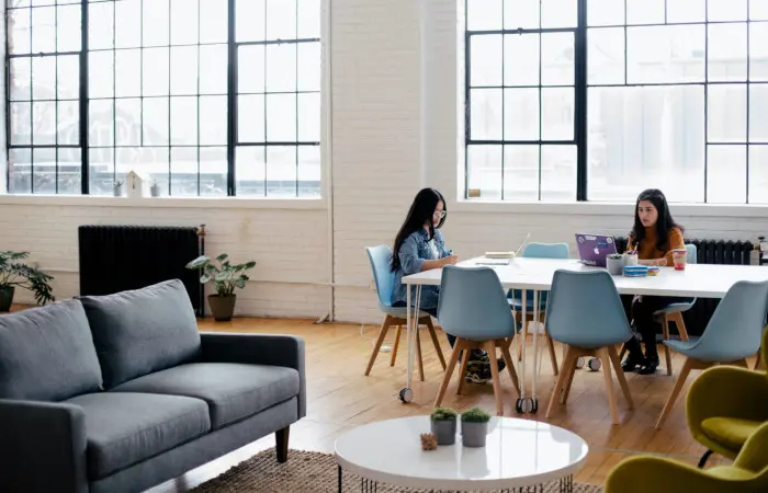 La sala común de una empresa con dos mujeres descansando.